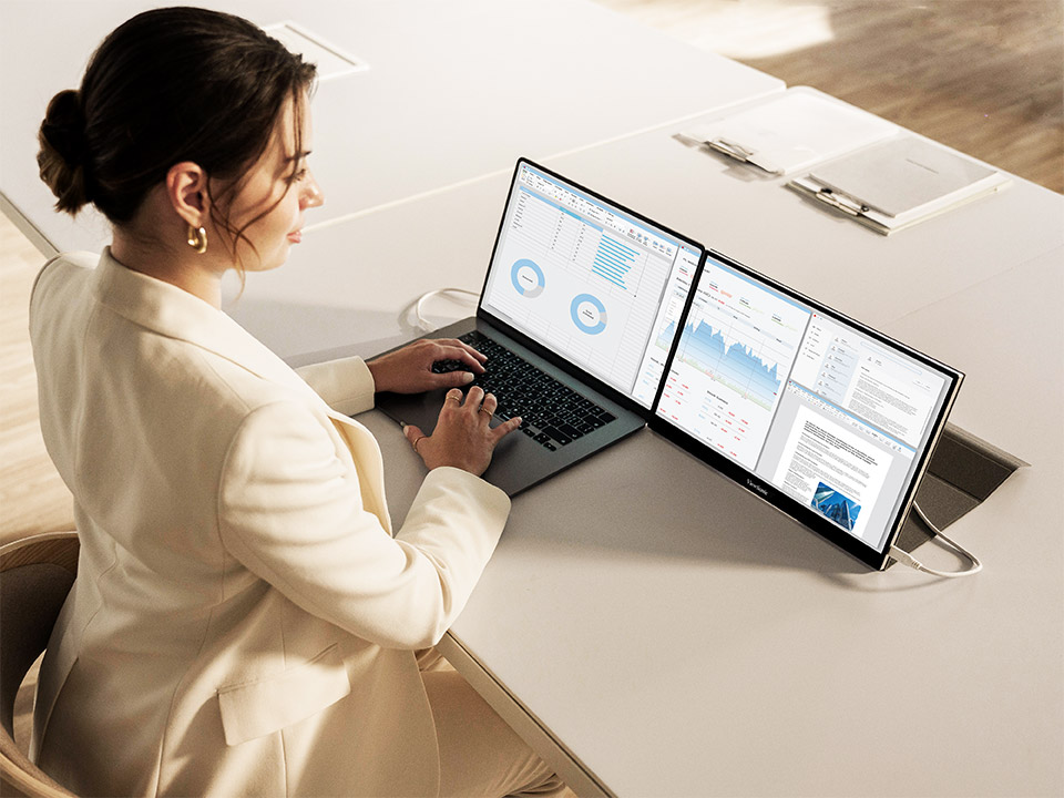 Professionnel utilisant une configuration double écran pour maximiser la productivité à distance.